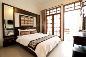 a bedroom with a large bed and a large window at de' Halimun Guest House in Bandung