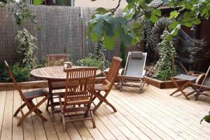 a wooden table and chairs on a wooden deck at La Maison du Rempart in Eguisheim