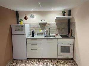 a kitchen with a white refrigerator and a sink at I VACANZIERI in Avola