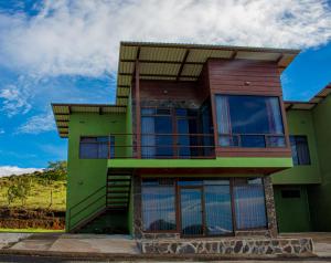 una casa verde con balcón en la parte superior. en Sunset Vista Lodge,Monteverde,Costa Rica., en Monteverde