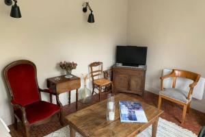 a living room with a tv and a table and chairs at LA PETITE MAISON de Chenillé Changé in Chenillé-Changé