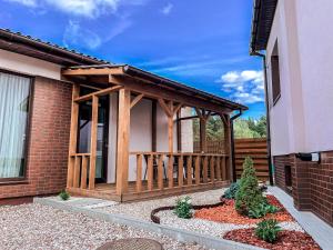 a wooden gazebo on the side of a house at Royal Resident in Druskininkai