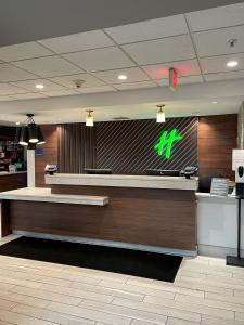 a check in counter of a store at Holiday Inn & Suites Syracuse Airport - Liverpool, an IHG Hotel in Liverpool