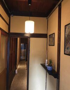 a hallway with a door and a chandelier in a room at Machiya Kikunoya in Nagoya