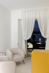 a living room with a couch and a chair and a window at Malalbergo in Reggio Calabria