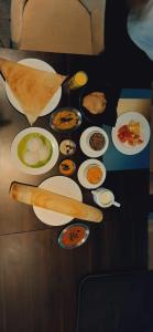 a table with many plates of food on it at The Terrace by Ladder Mgd by Citrine in Trivandrum