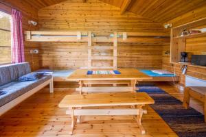 una stanza con tavoli e panche in legno in una cabina di Ahvenlampi Camping a Saarijärvi