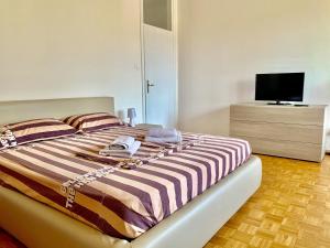 Dormitorio con cama y tocador con TV en Appartamento Bolzano - Vittorio Veneto - Parcheggio incluso, en Bolzano