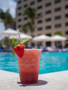 a strawberry drink sitting on a table next to a pool at InterContinental Miami, an IHG Hotel in Miami