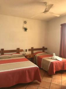 a room with two beds and a ceiling at Hotel Colonial Rivera in Iguala de la Independencia