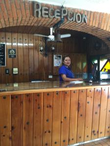 a woman standing at a counter in a restaurant at Hotel Colonial Rivera in Iguala de la Independencia