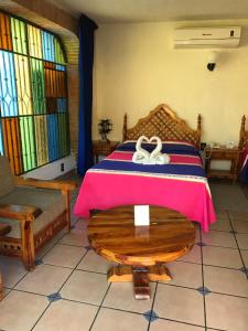 a bedroom with a bed and a table and stained glass windows at Hotel Colonial Rivera in Iguala de la Independencia +10 photos