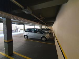 a small silver car parked in a parking garage at JF Flat - Hotel in Ribeirão Preto
