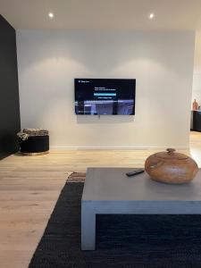 ein Zimmer mit einem Tisch und einem Fernseher an der Wand in der Unterkunft NEOZONE Appart-Hotel Malmedy in Malmedy