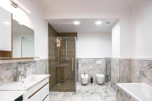 een badkamer met een douche en 2 toiletten. bij Sky House Premium Rent in Chişinău