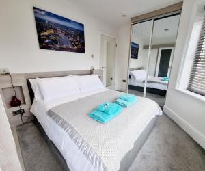 a bedroom with a bed with two towels on it at Bournemouth Luxury Apartment in Bournemouth