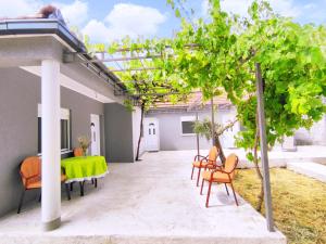 een patio met een groene tafel en stoelen bij Celtis Shade House in Virpazar