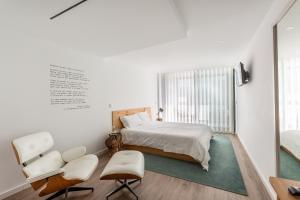 ヴィラ・ド・コンデにあるAutor Guesthouseのベッドルーム1室(ベッド1台、白い椅子2脚付)