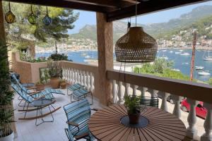a balcony with tables and chairs and a view of the water at Beach Apartment Montemar No.1 - perfect ocean view in Sóller
