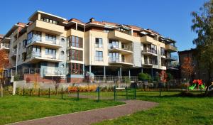 an apartment building with a park in front of it at Apartamenty Marina House in Bydgoszcz