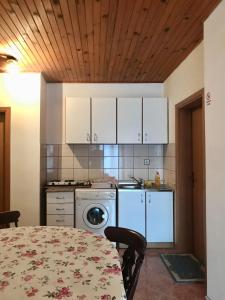 a kitchen with a table and a kitchen with white cabinets at Sobe Markočević in Teslić