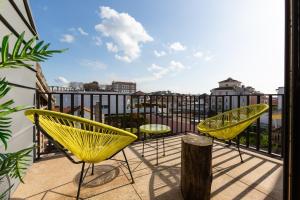 a balcony with yellow chairs and a view of the city at Autor Guesthouse in Vila do Conde