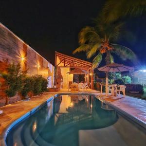 una piscina frente a una casa por la noche en Casa no Barro Preto - Vila da Praia, Iguape - Ceará, en Aquiraz