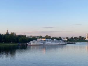 a cruise ship on the water with a city in the background at Уютные апартаменты на Речном in Tver