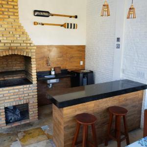 - une cuisine avec un comptoir et une cheminée en briques dans l'établissement Casa no Barro Preto - Vila da Praia, Iguape - Ceará, à Aquiraz
