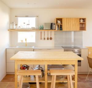 a kitchen with a wooden table and a sink at Can Jove Cadaqués in Cadaqués
