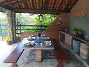 una mesa de madera con platos de comida en el patio en Casa Cantinho da Paz, seu lazer completo, churrasqueira, piscina e muita tranquilidade, en Gravatá