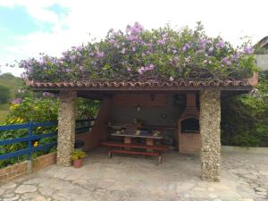 a gazebo with a table and flowers on it at Casa Cantinho da Paz, seu lazer completo, churrasqueira, piscina e muita tranquilidade in Gravatá