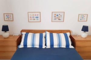 a bedroom with a bed with blue and white pillows at Cozy beach front apartment in Portimão