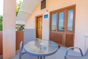 a glass table and chairs in front of a door at Villa Vadian & Pool in Gevgelija