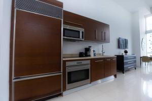 a kitchen with wooden cabinets and a microwave at ICON/W HOTEL LUXURY STUDIO@MIAMI DOWNTOWN/BRICKELL in Miami