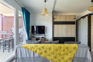 - une chambre avec un lit et une couverture jaune dans l'établissement Superbe studio, vue lac, Spirou, rando, velo, à Monteux