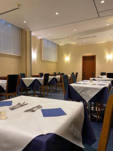 a conference room with tables and chairs with blue tablecloths at Nicotel Barletta in Barletta