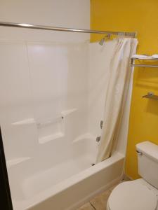 a bathroom with a white tub and a toilet at Travelodge by Wyndham Stockton in Stockton