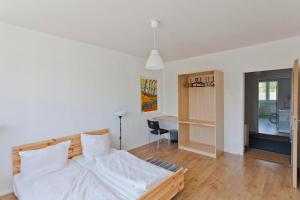 1 dormitorio con cama con sábanas blancas y escritorio en Last Minute Rügen, en Lohme