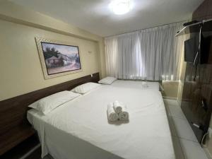 a small bedroom with a bed with two towels on it at Apt 219 in João Pessoa +35 photos