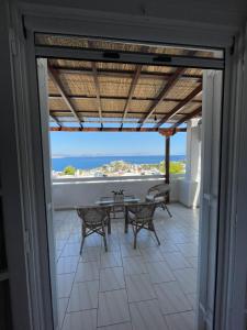 balcón con mesa, sillas y vistas al océano en 180° View to Sea, en Vathí
