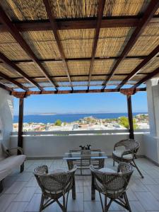 a patio with chairs and tables and a view of the ocean at 180° View to Sea in Vathí