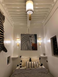 a bedroom with a bed and a painting of a zebra at Riad Dada Mouss & Suites in Marrakech