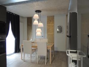 a dining room with a table and white chairs at Blue Sky House in Baloteşti