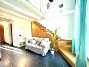 - un salon avec un canapé et un escalier dans l'établissement COZY LOFT MARINA VIEW, à Savone