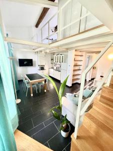 COZY LOFT MARINA VIEW في سافونا: غرفة معيشة بها درج وطاولة