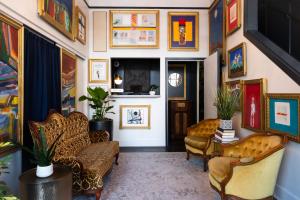 una sala de estar con sillas y pinturas en las paredes. en The Metro Hotel en San Francisco
