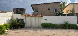 a house with a white fence and a garage at Ap07-A 50 Metros da Praia Flats Completamente Mobiliados in Paulista