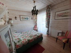 a bedroom with a bed and a chair in a room at Villa "Le Mirage" in Cap-Ferret