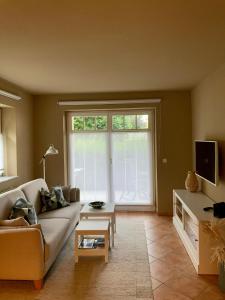 ein Wohnzimmer mit einem Sofa und einem großen Fenster in der Unterkunft Auszeit am Lindenpark in Kühlungsborn